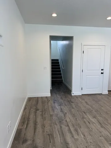 Wood-finish flooring throughout, featuring a bright white color palette and recessed lighting