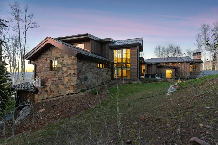 Stone and wood-clad exterior with a multi-level architectural design