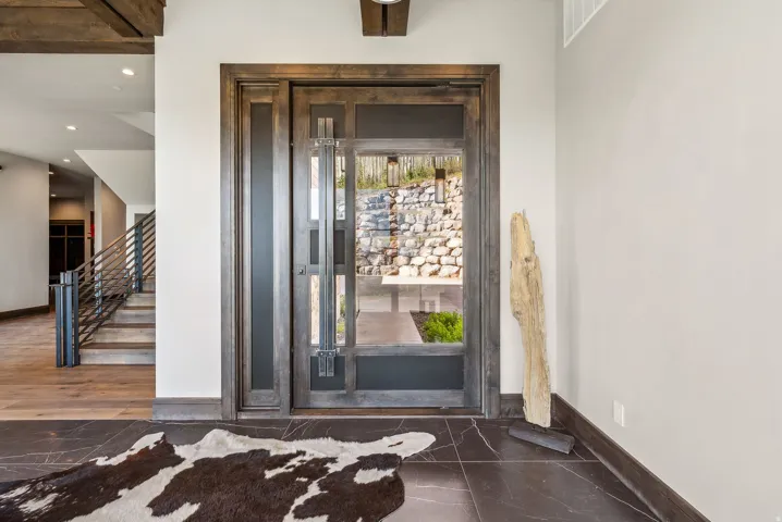 Grand entry featuring a solid wood door with glass paneling, sidelight, and transom window