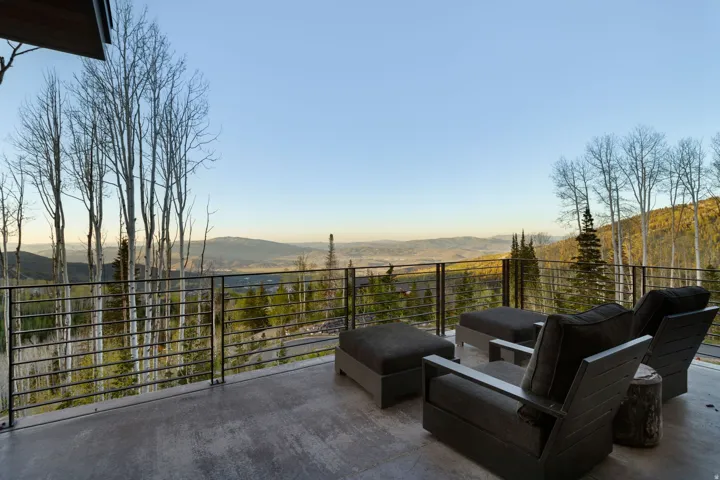 Expansive outdoor deck featuring a concrete surface and horizontal metal railings