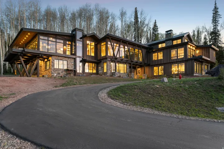 Custom-built residence featuring extensive stonework, wood siding, and prominent exposed beams