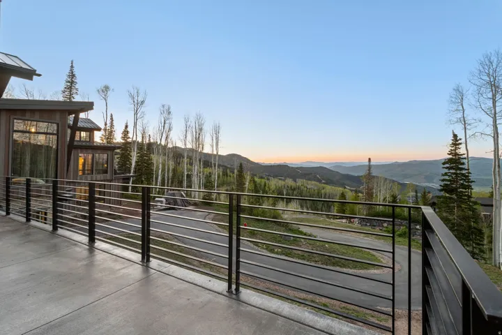 Expansive concrete deck featuring a modern horizontal cable railing system
