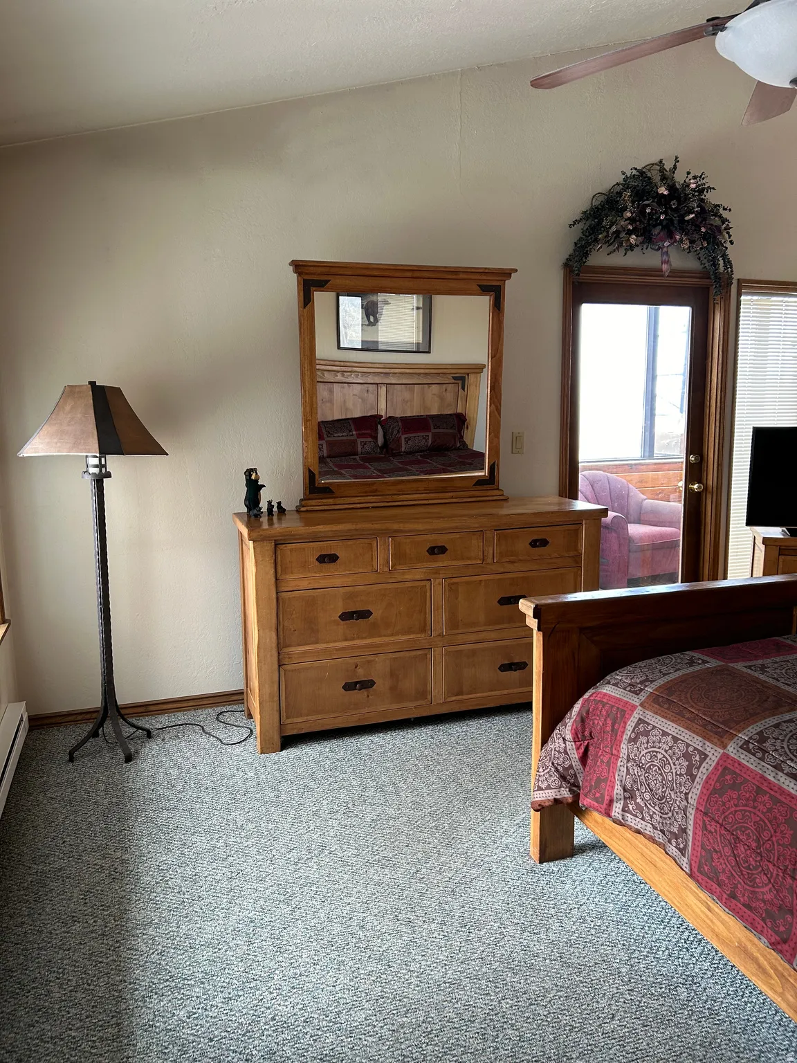Vaulted ceiling room featuring a wood-frame dresser with mirror