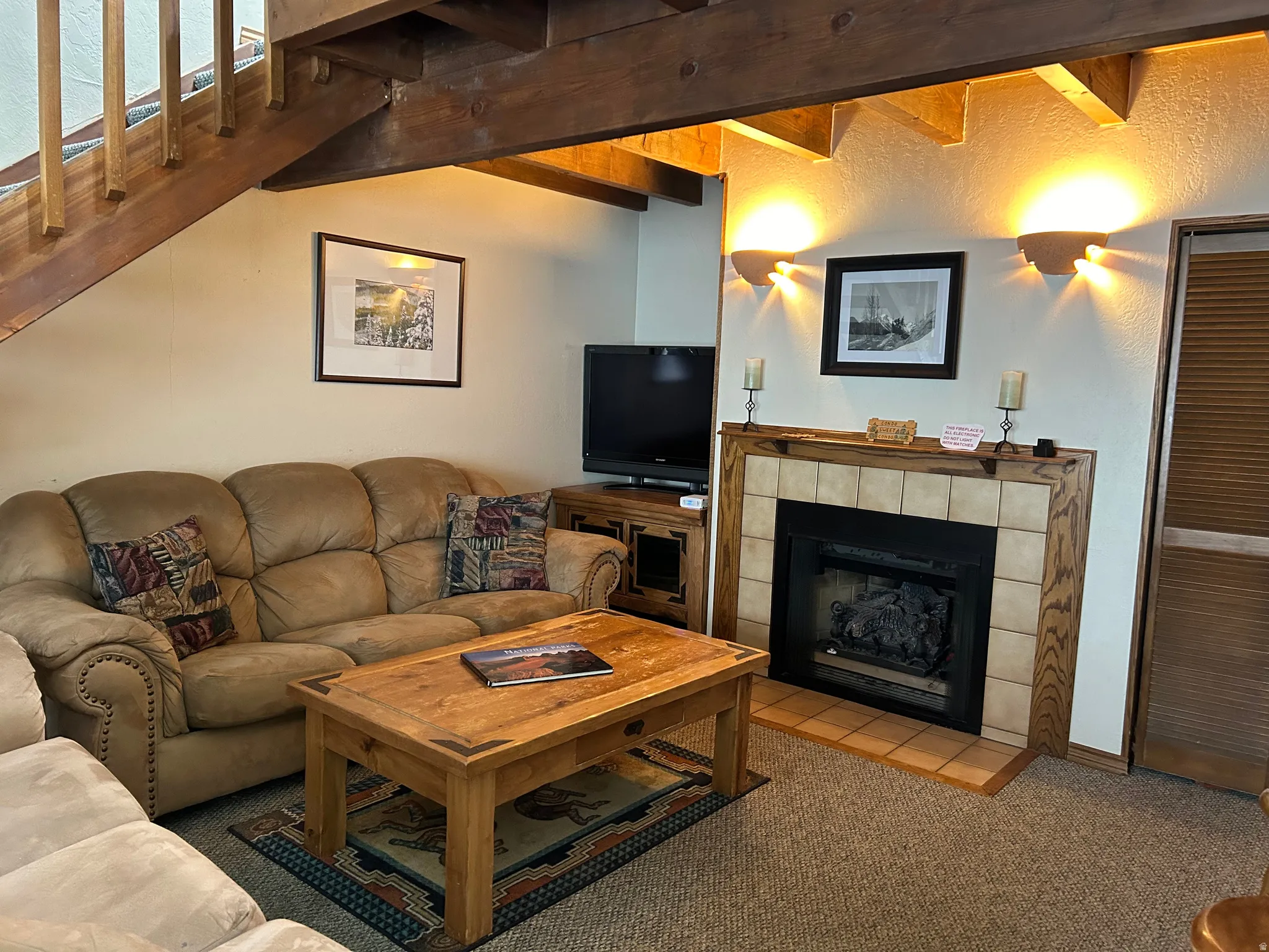 Living area featuring a fireplace with a tiled surround and wood mantel