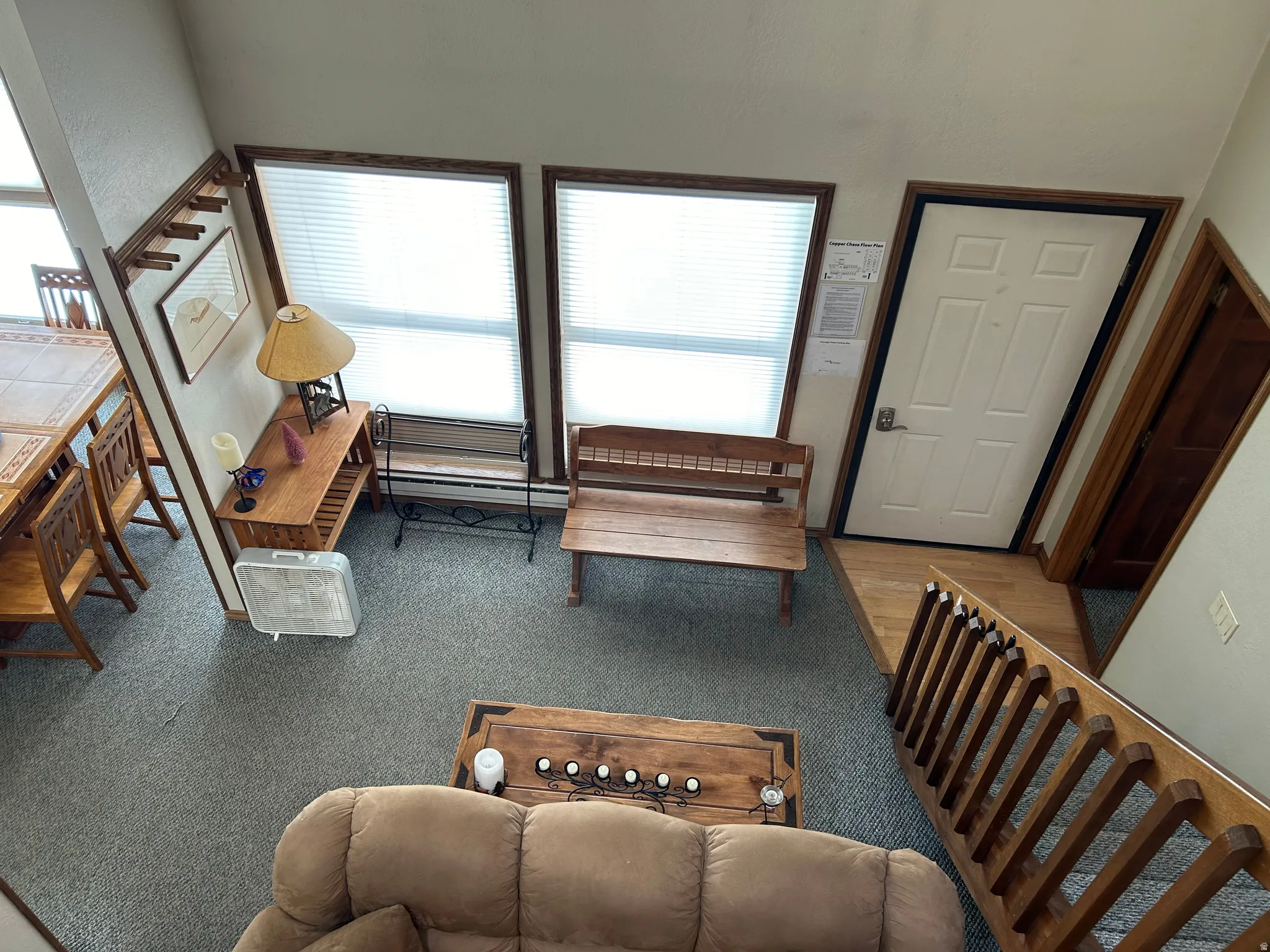 Entryway featuring a solid wood door with dark trim, wood-finish flooring, and a wooden staircase with balusters