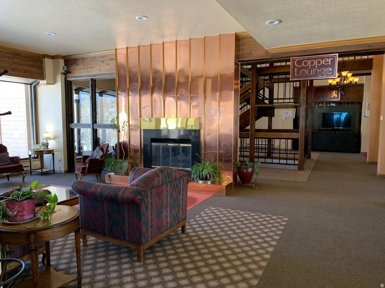 Lounge area featuring a prominent copper-clad fireplace with a black hearth