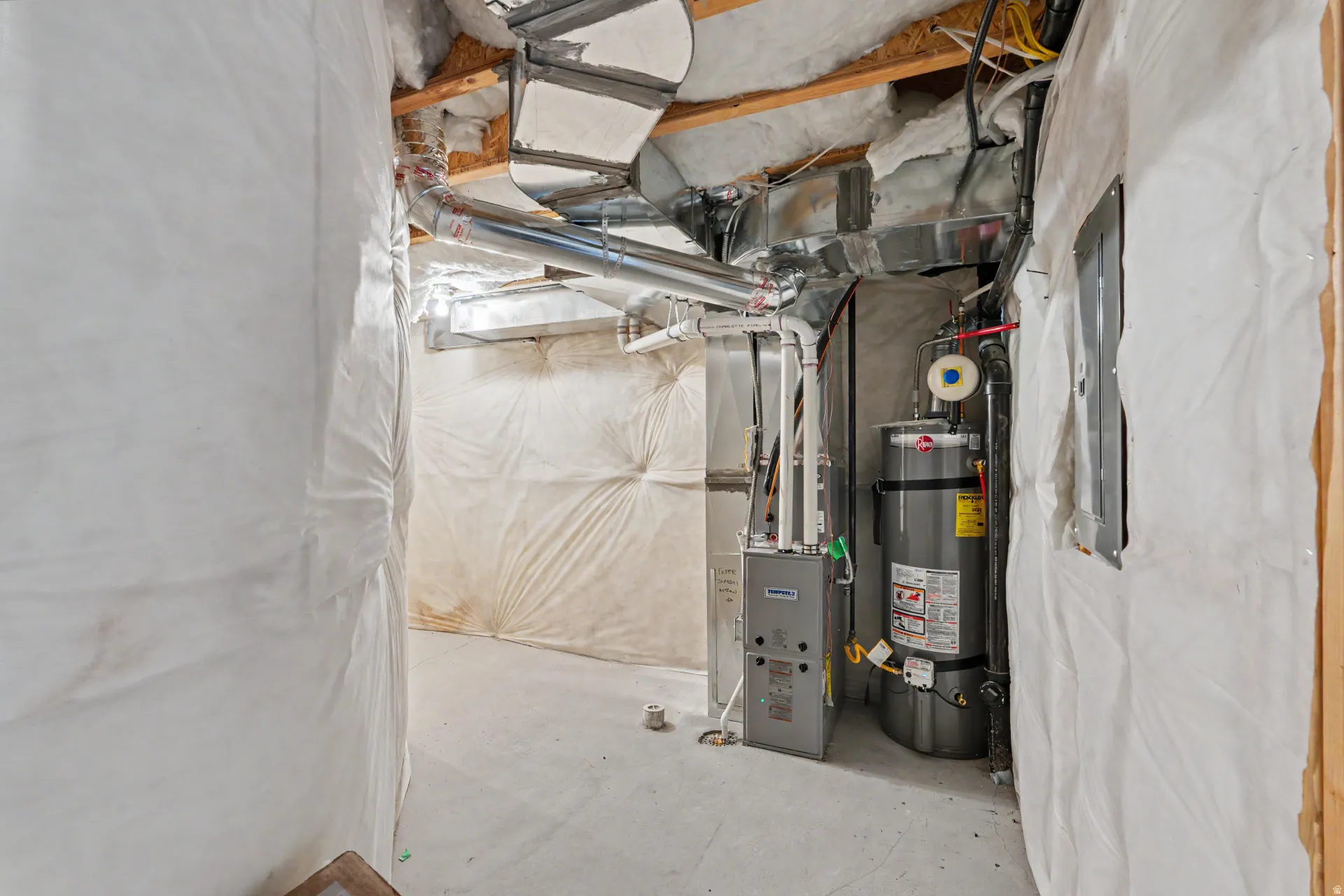 Utility area featuring a water heater, furnace, exposed ductwork, and insulation