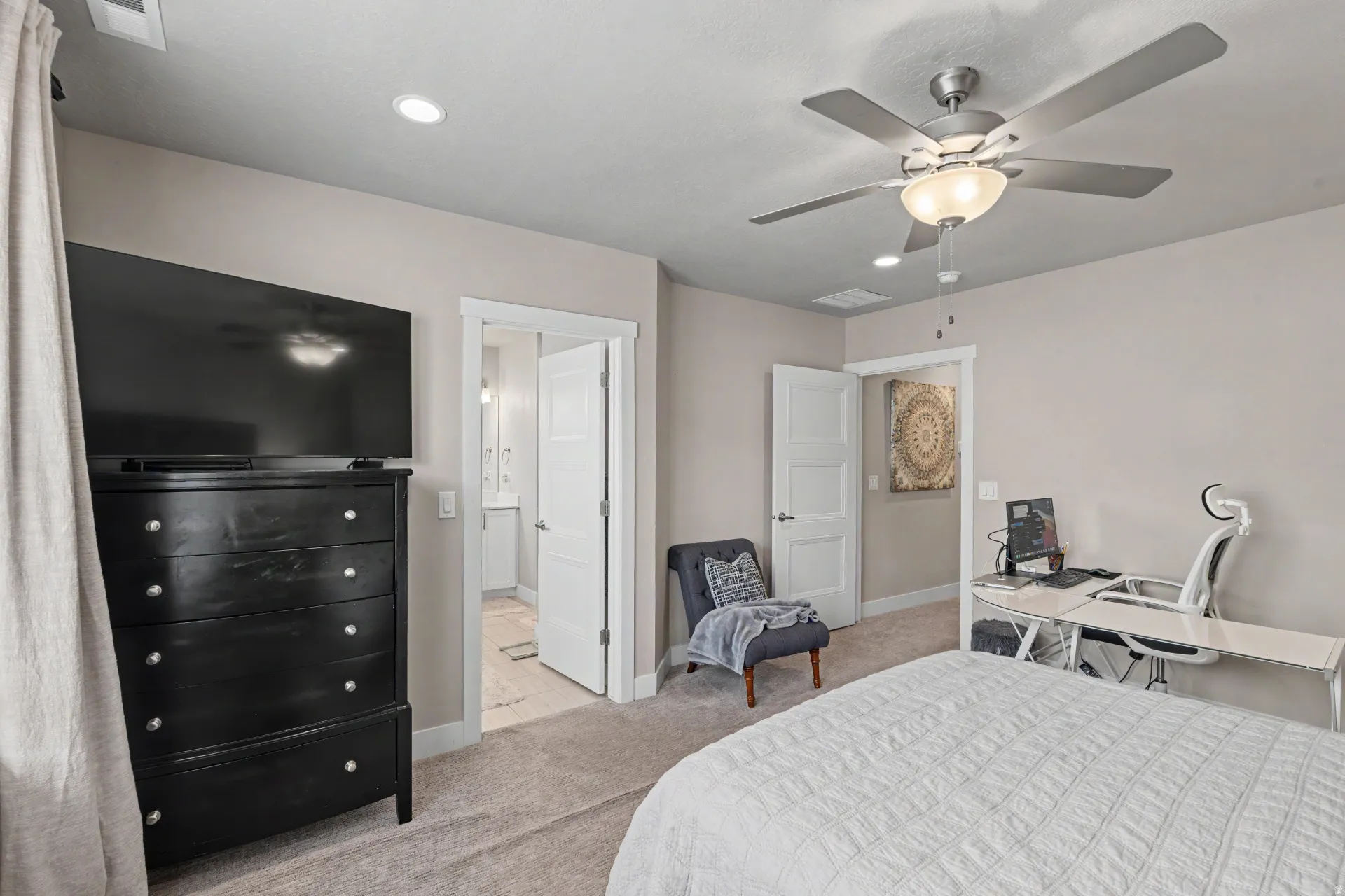 Carpeted room featuring a ceiling fan with integrated lighting, recessed lighting, and a white paneled door