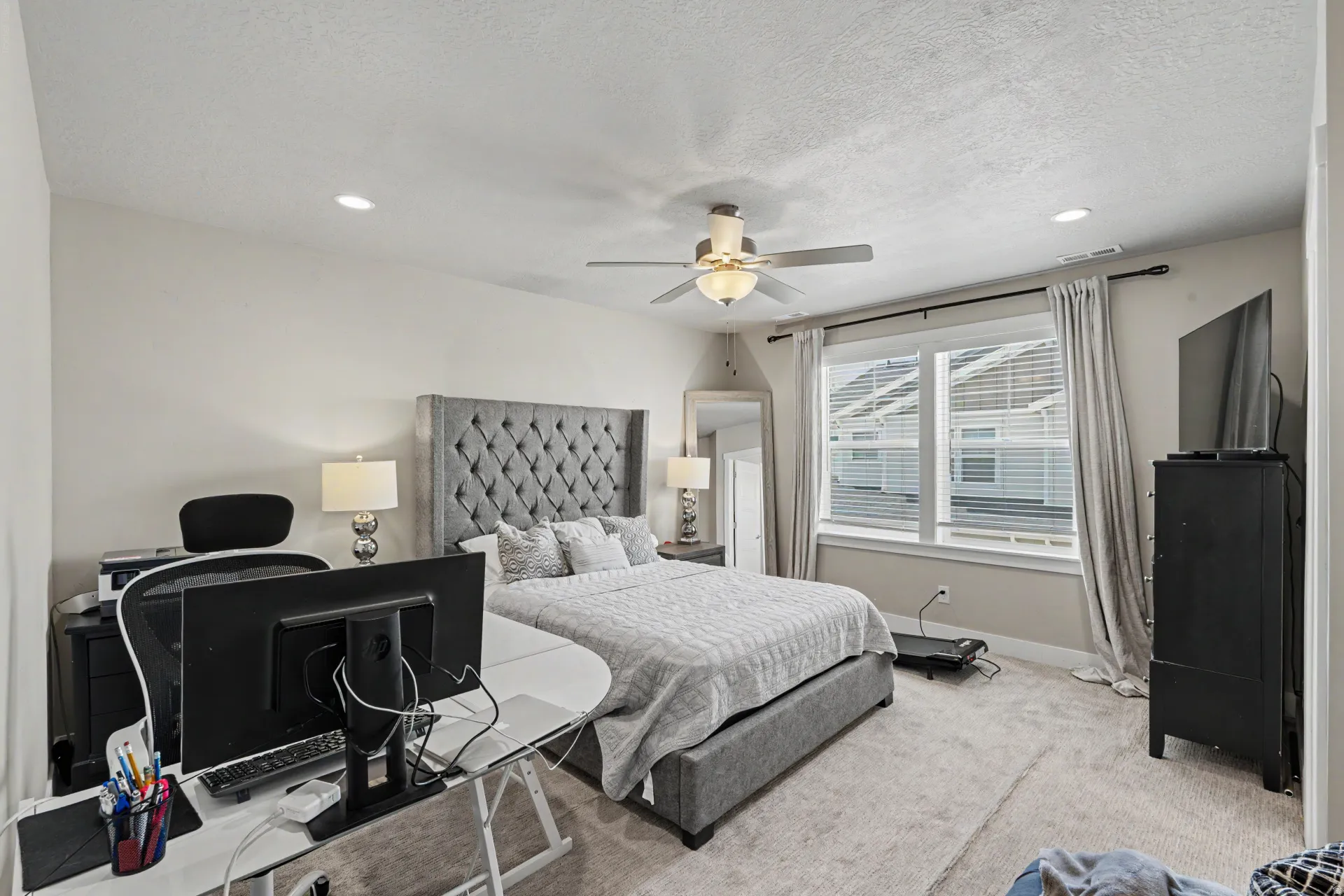 Carpeted bedroom featuring a large window, recessed lighting, and a ceiling fan with light fixture
