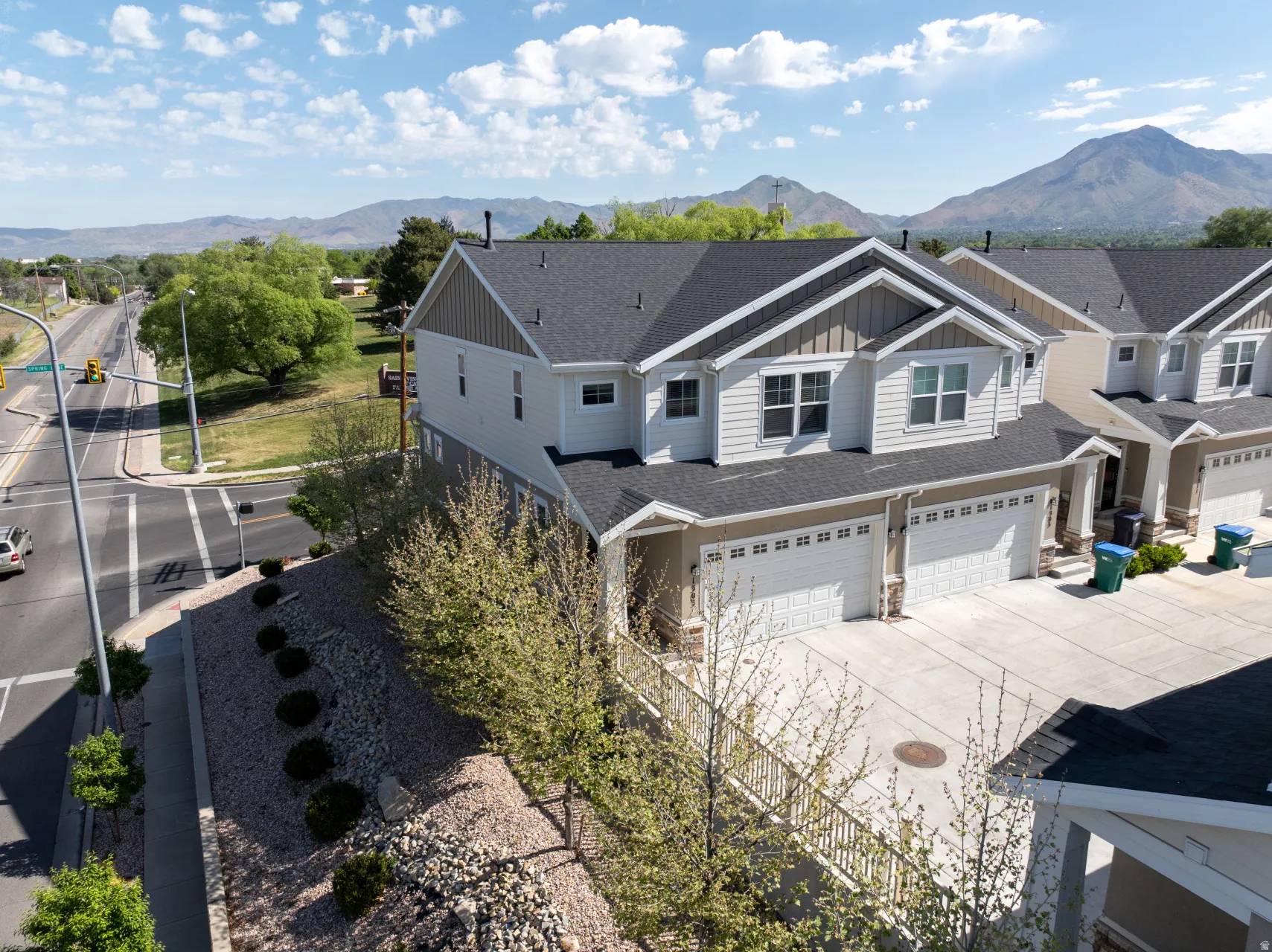 Contemporary multi-level residence featuring light-toned siding and dark shingle roofing
