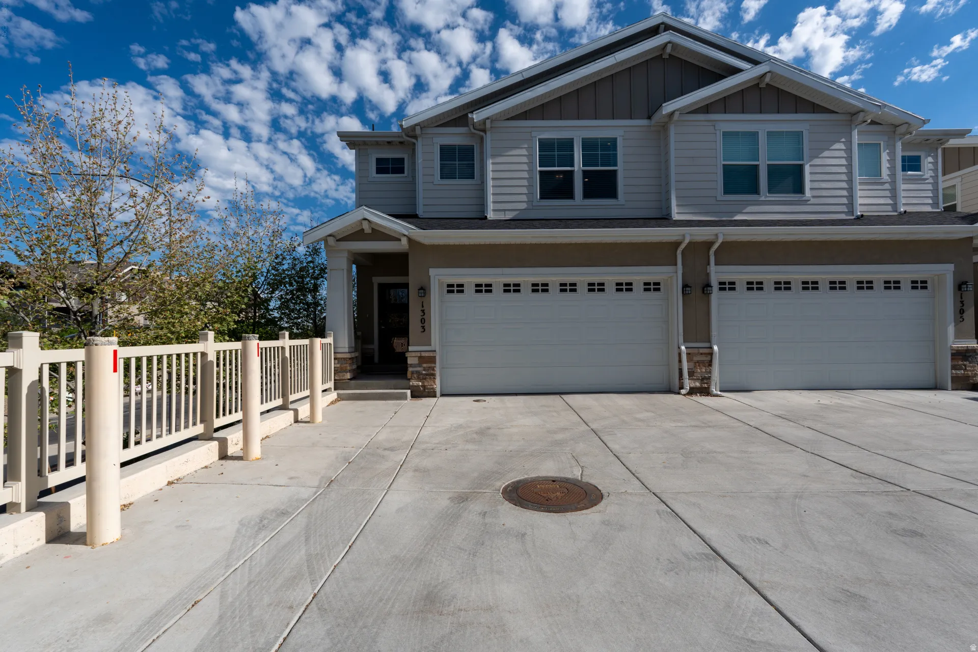 Contemporary multi-level exterior with a two-car garage, concrete driveway, and covered entry