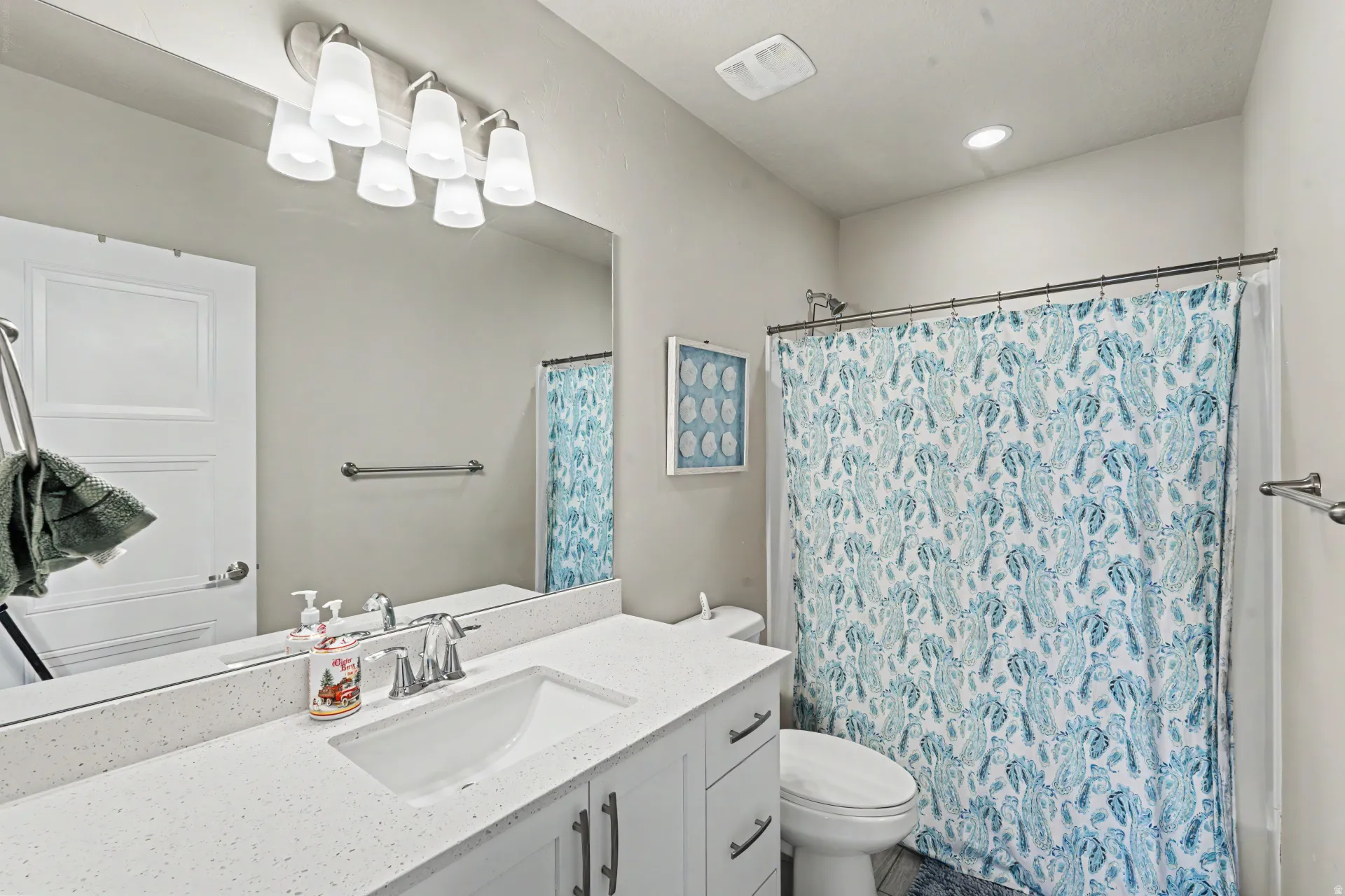 Bathroom featuring a white vanity with an integrated sink, polished chrome faucet, and a light-toned countertop