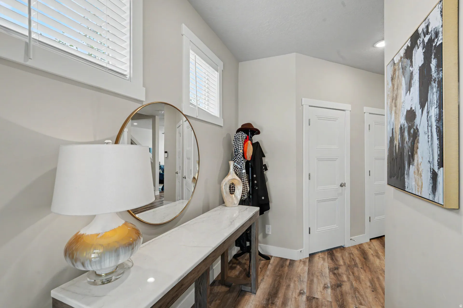 Entryway featuring wood-finish flooring, light neutral wall tones, and white trim