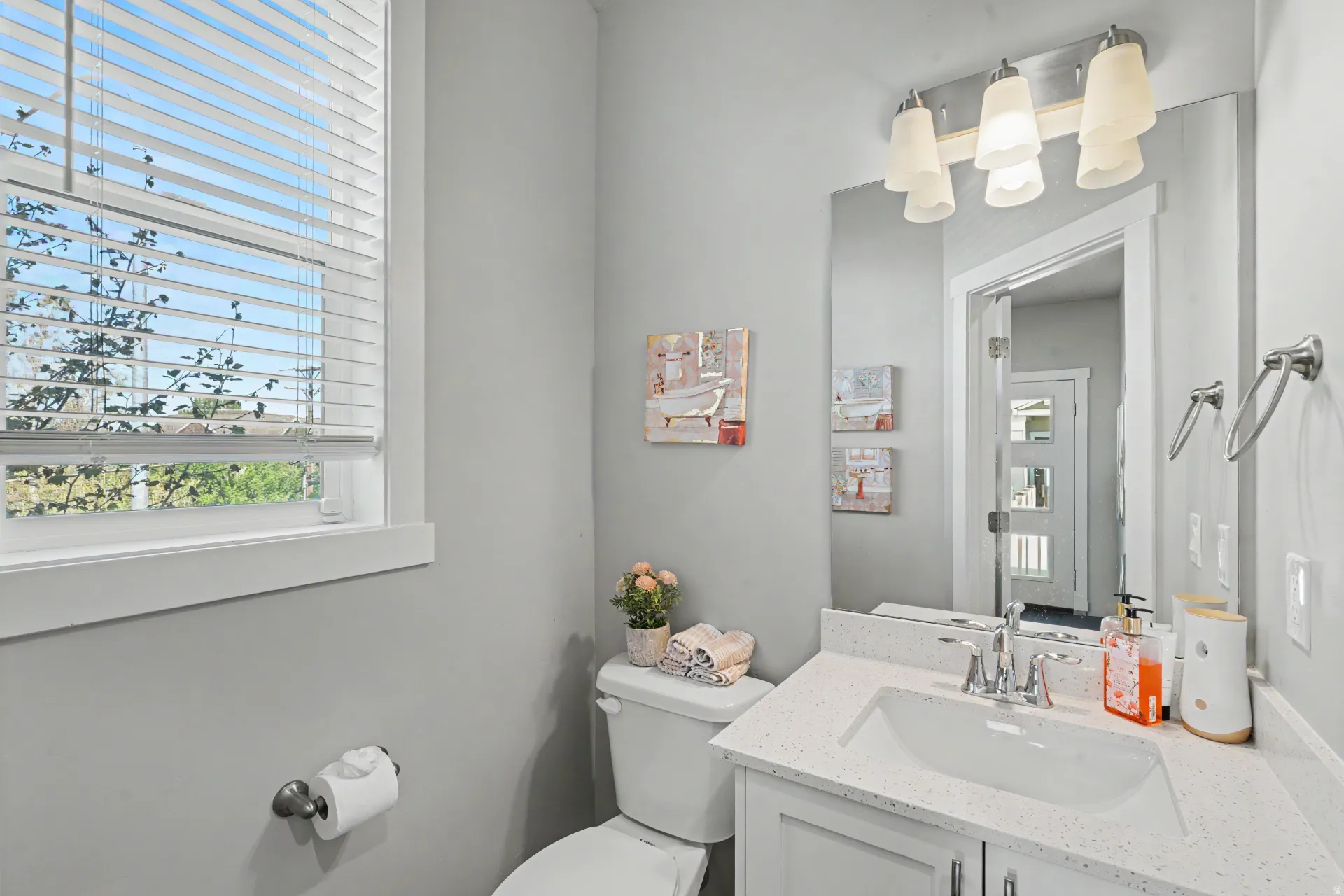 Full bathroom featuring a white vanity with an integrated sink, a speckled white countertop, and a chrome faucet