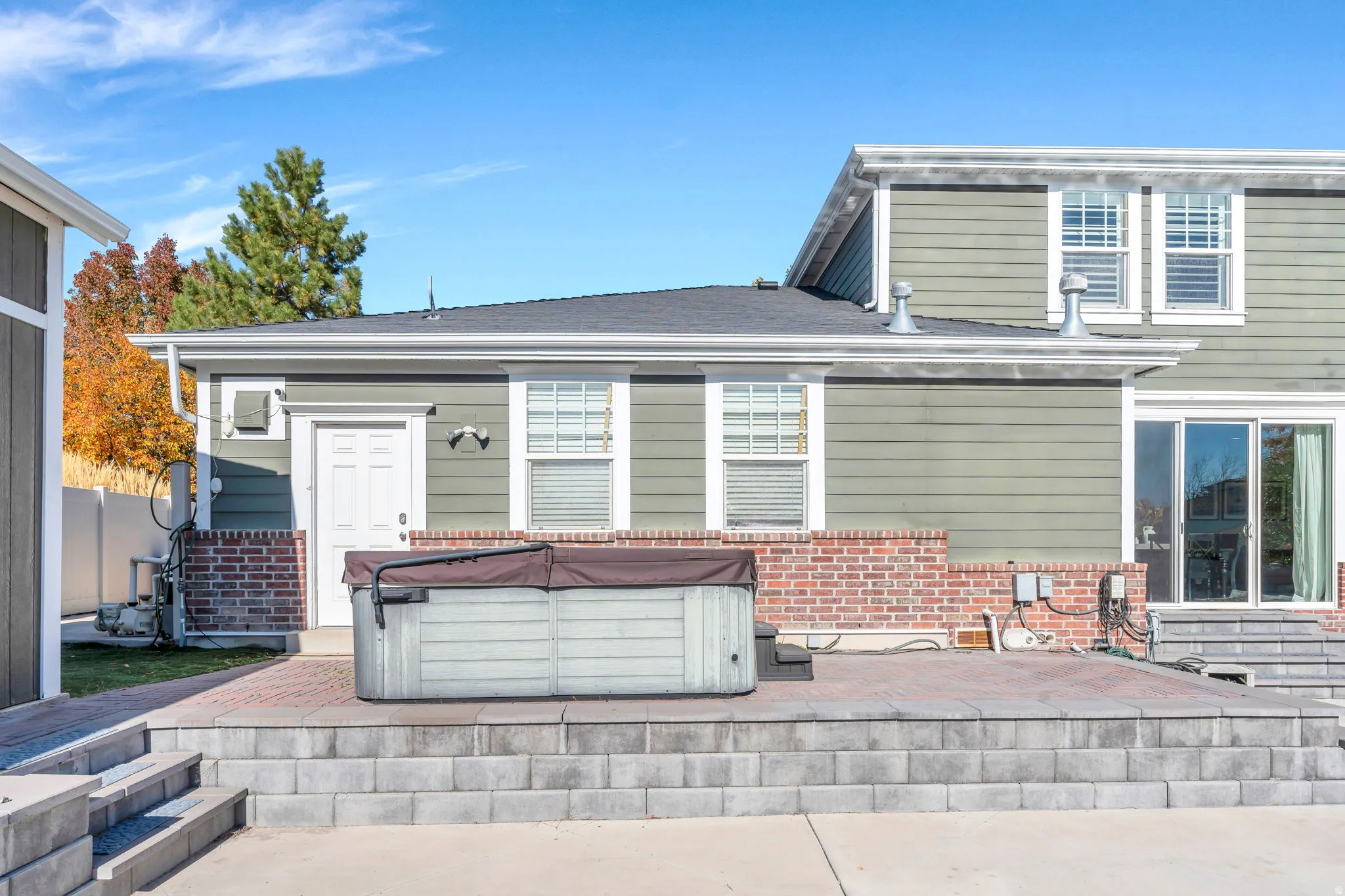 Rear view of house with a patio, and hot tub