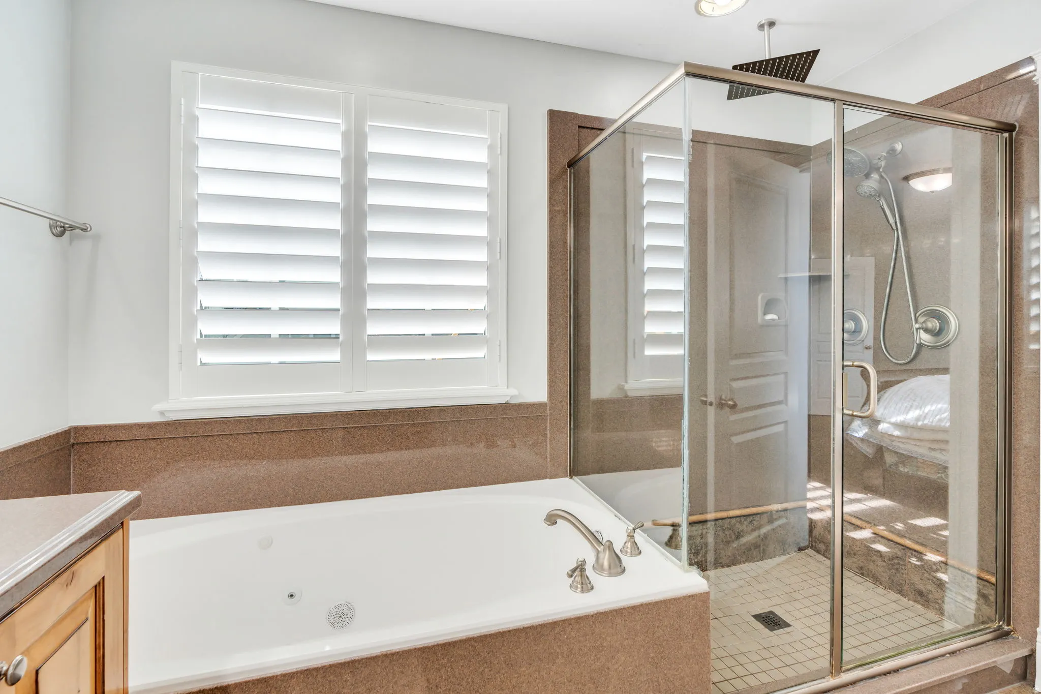 Ensuite bathroom with glass enclosed shower and jetted tub