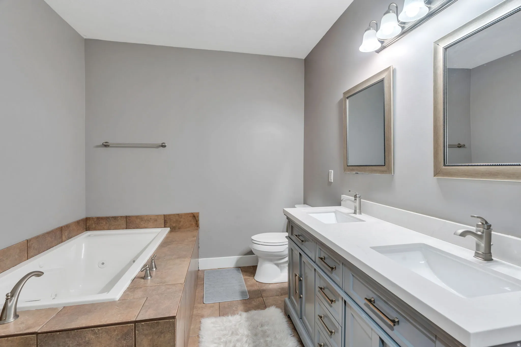 Full bathroom with a jetted tub, and double vanity