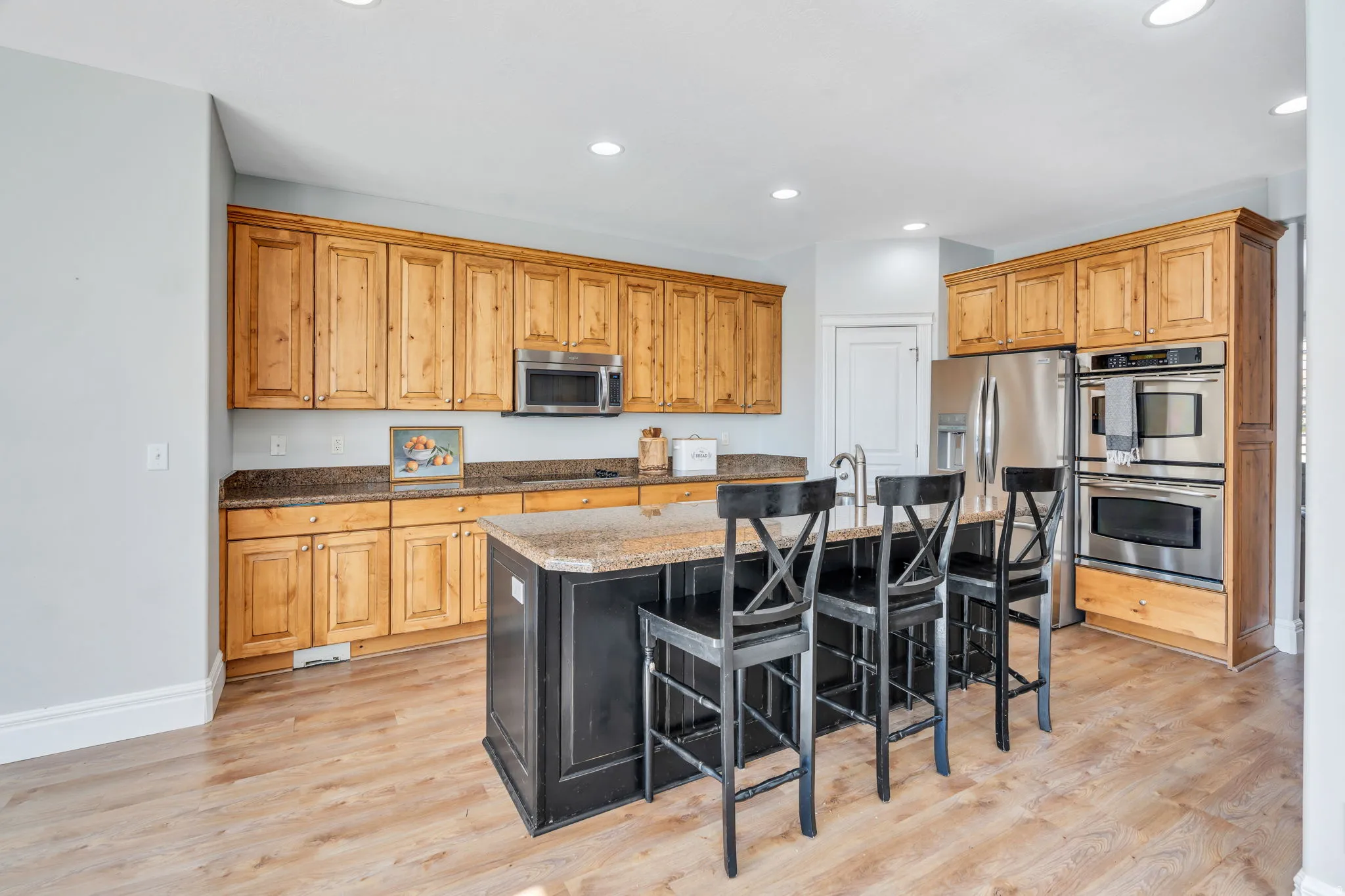 Kitchen featuring stainless steel appliances, granite countertops, and a kitchen island with sink