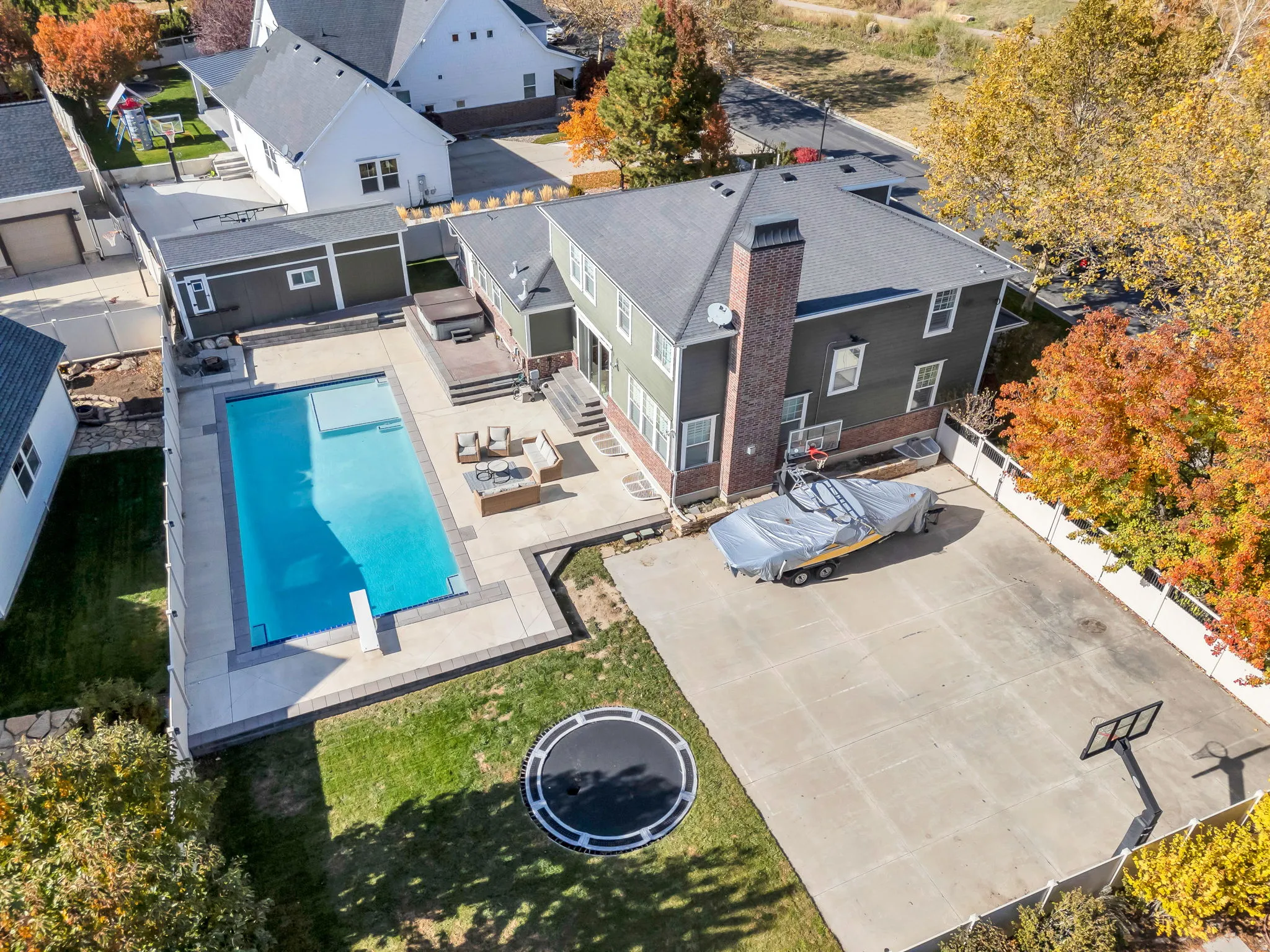 View of subject property with a pool area, jacuzzi, storage shed and full basketball court