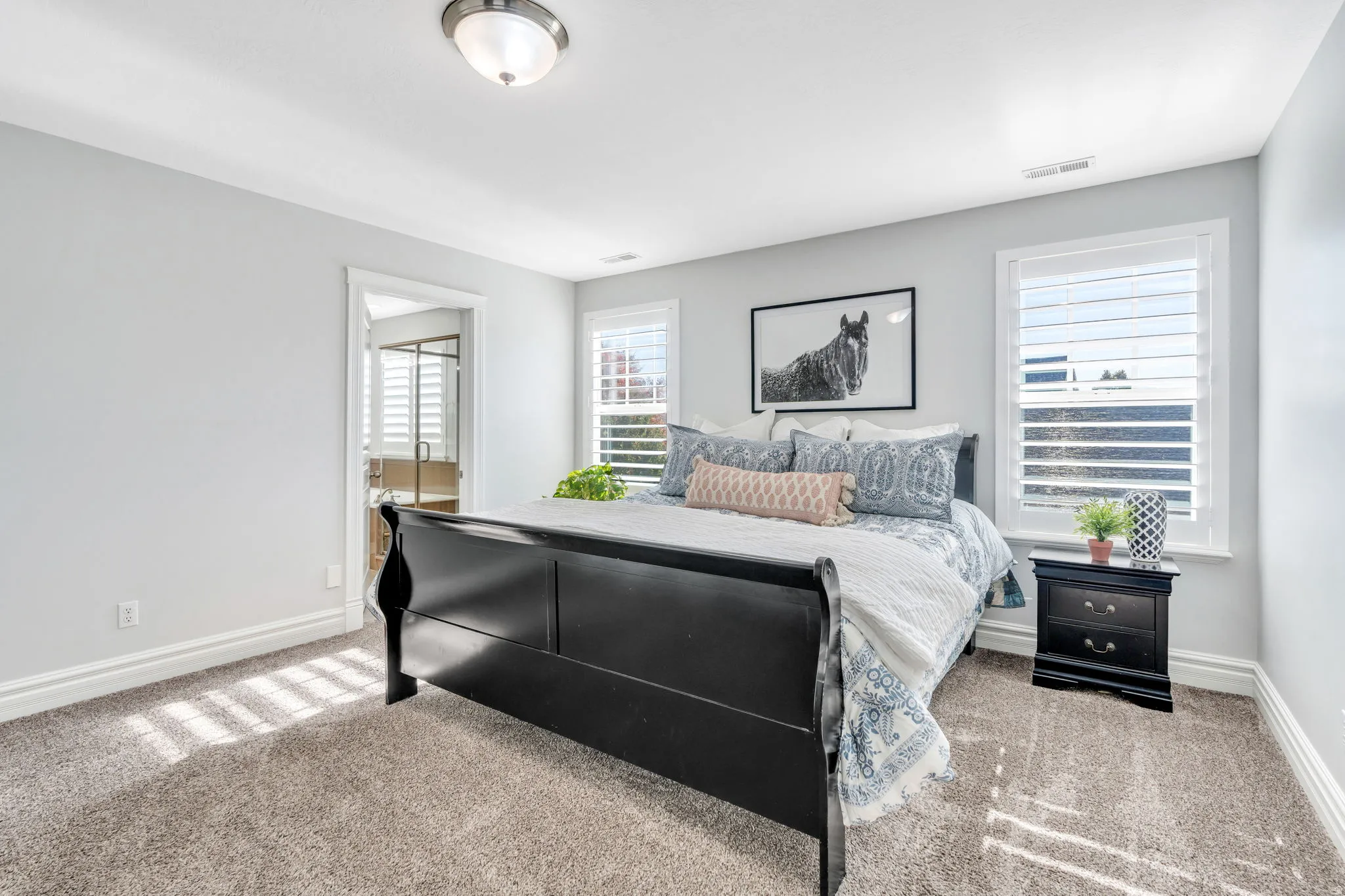 Primary bedroom with light carpet and ensuite bath