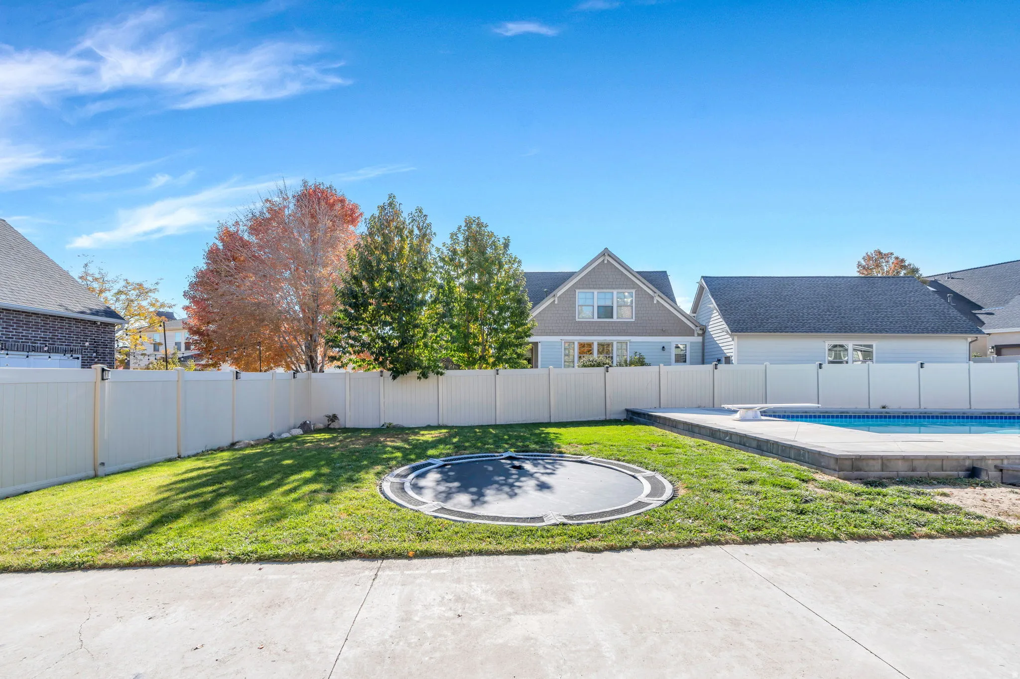 Fenced backyard with in-ground trampoline