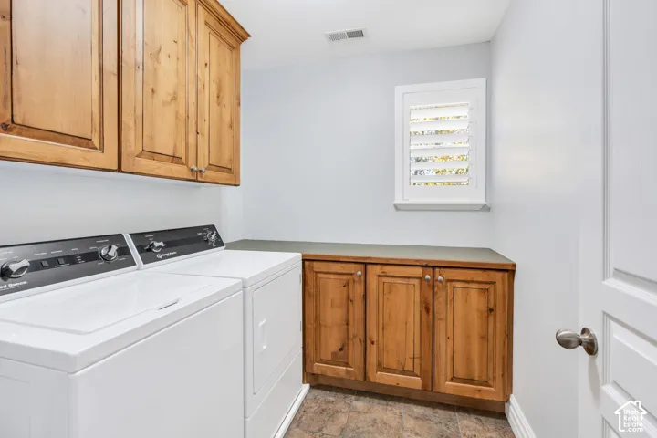 Laundry room featuring cabinet space, separate washer and dryer