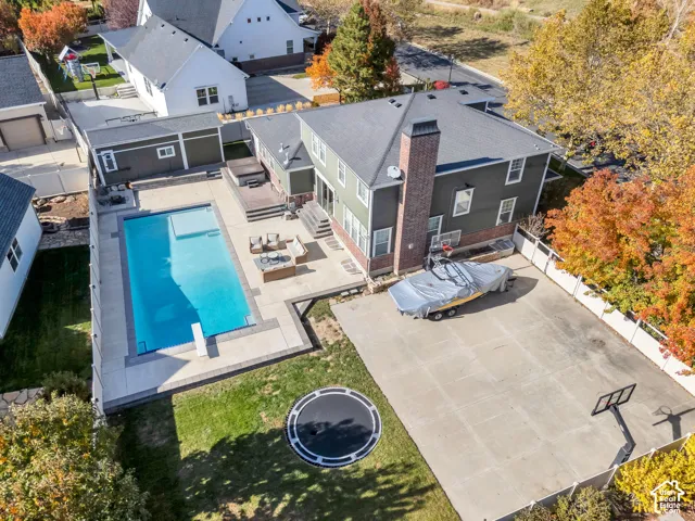 View of subject property with a pool area, jacuzzi, storage shed and full basketball court