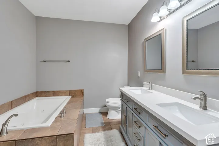 Full bathroom with a jetted tub, and double vanity