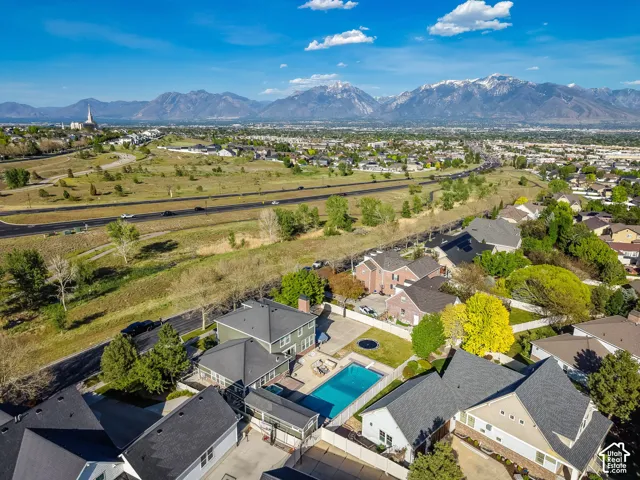 Aerial perspective of a residential area with varied rooflines and a prominent pool
