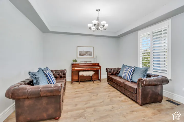 Formal living room with light LVP floors, and a raised ceiling