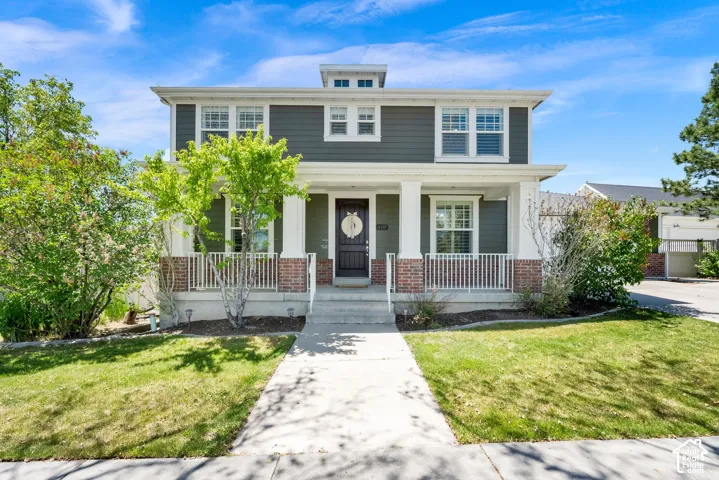 Two-story exterior with dark siding, white trim, and a prominent front porch