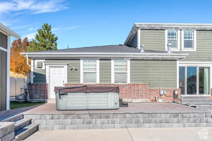 Rear view of house with a patio, and hot tub