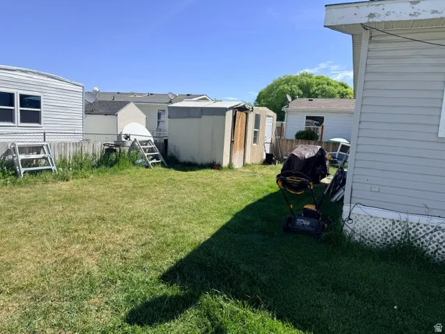 Expansive backyard featuring a partial chain-link fence, two storage sheds, and a wood privacy fence