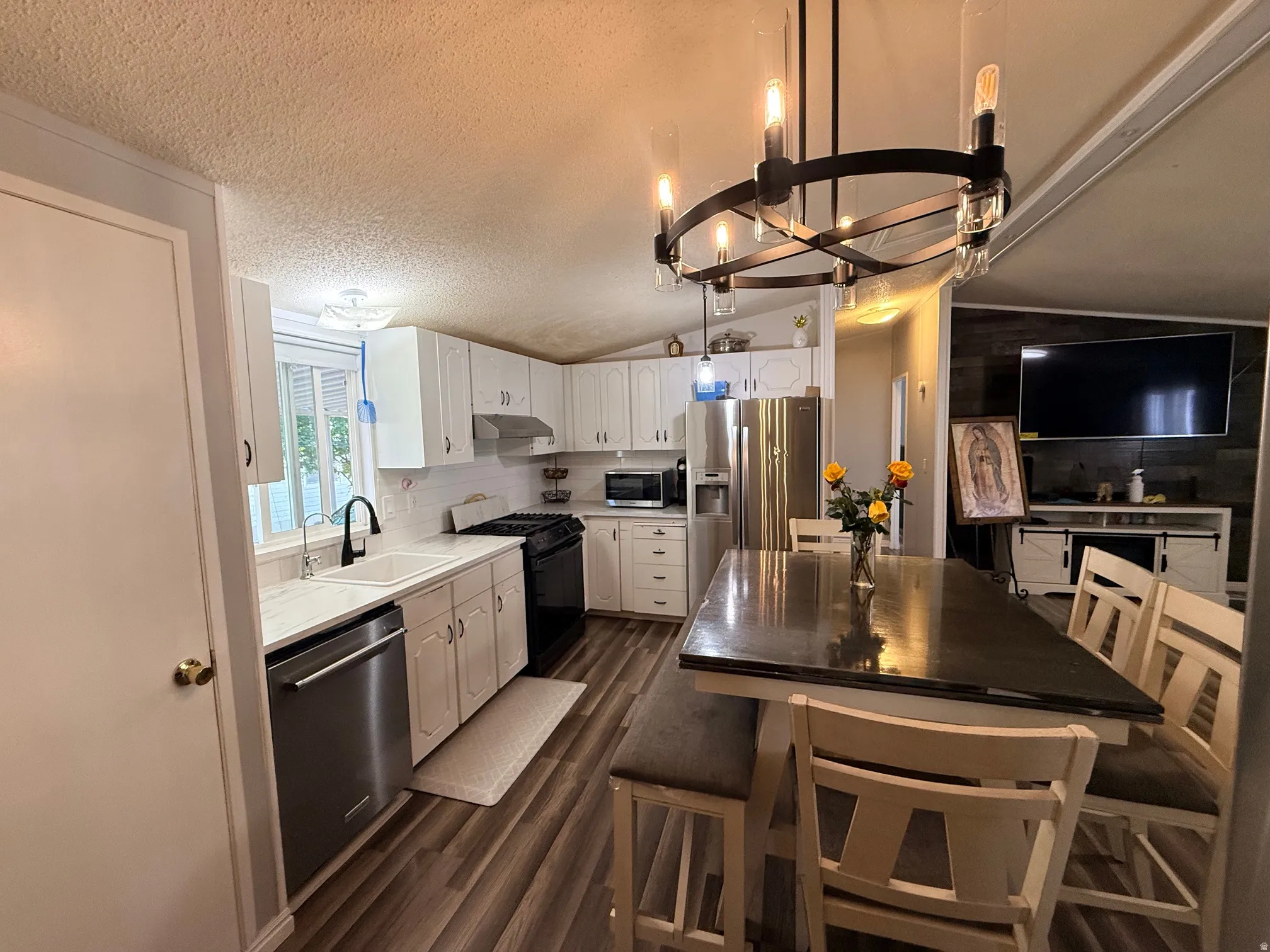 Modern kitchen featuring white cabinetry, a white subway tile backsplash, and wood-finish flooring