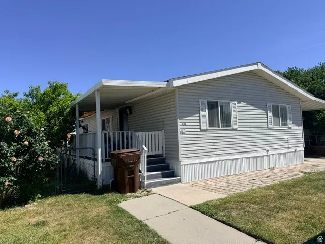 Manufactured home with light-colored siding and a covered front porch