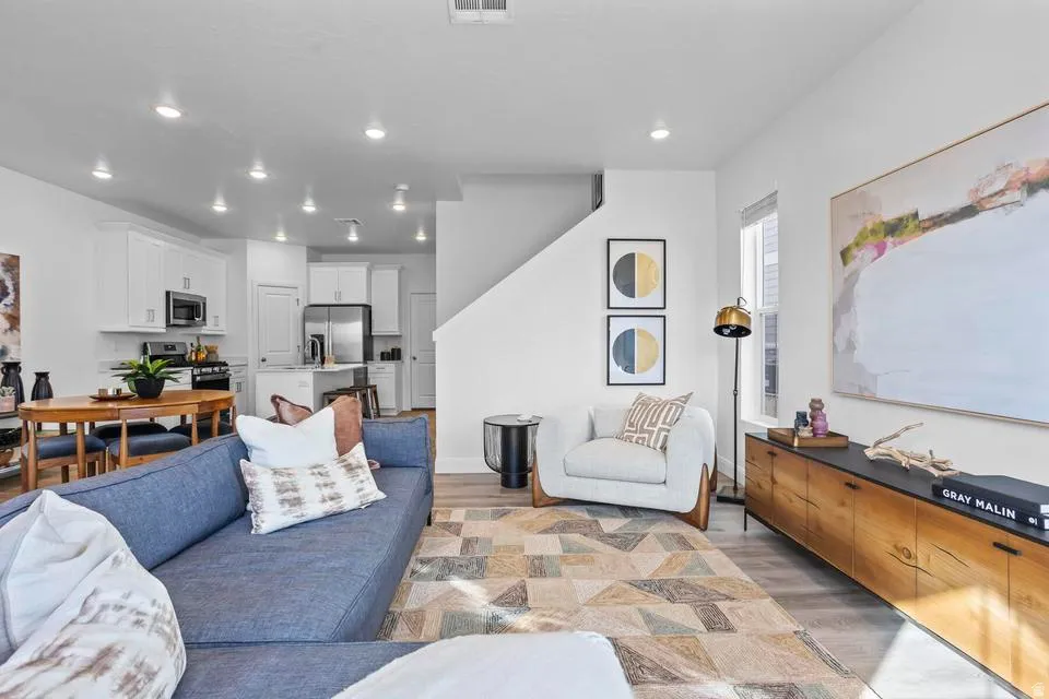 Open-concept living space featuring wood-finish flooring, recessed lighting, and a window for natural illumination
