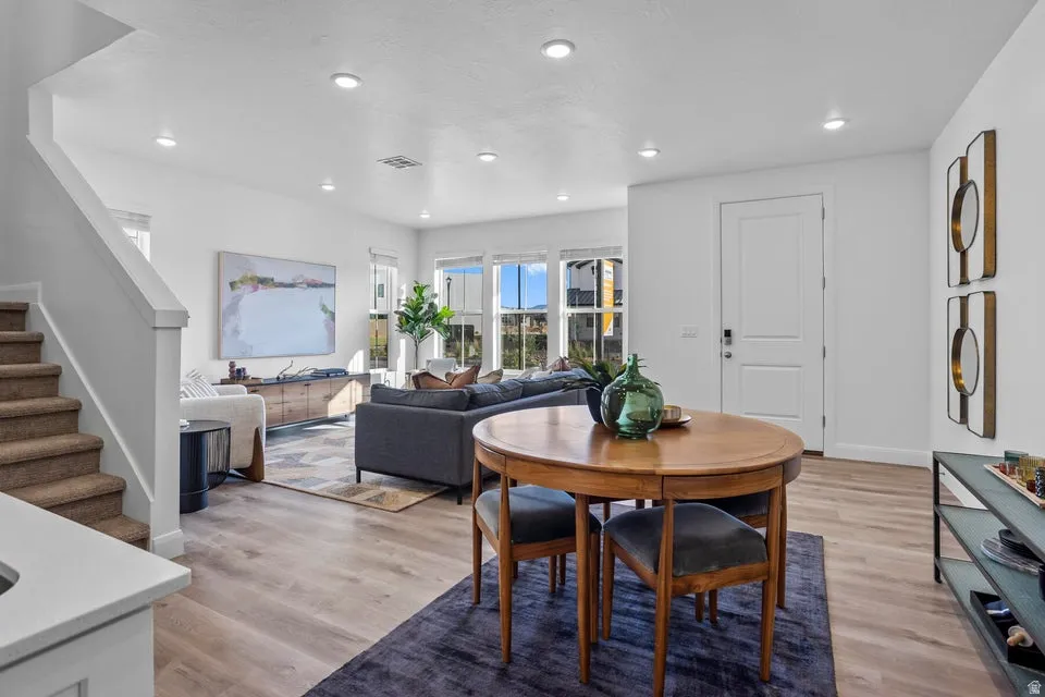 Open-concept living space featuring wood-finish flooring, recessed lighting, and a neutral color palette