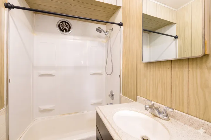 Bathroom featuring a white tub and shower surround with an integrated shower head
