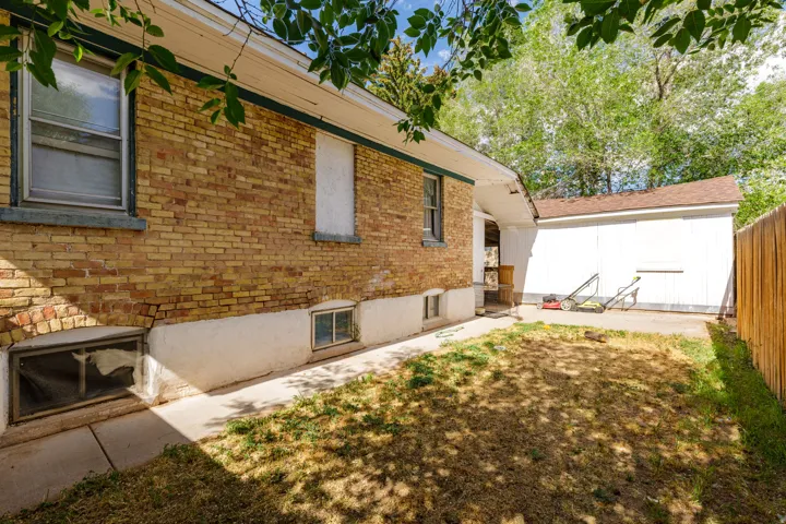 Brick exterior featuring multiple windows and a white painted foundation