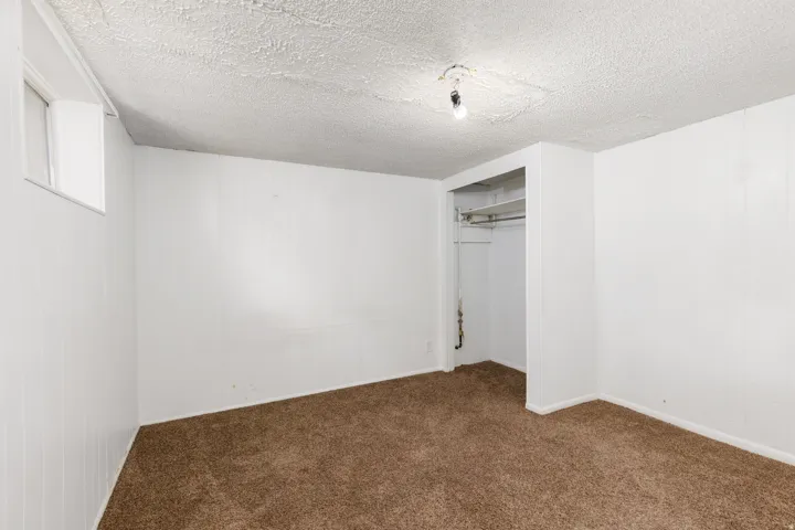 Room featuring neutral carpeting, white paneled walls, and a recessed window