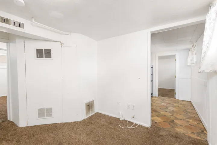 Carpeted room with white painted walls and ceiling