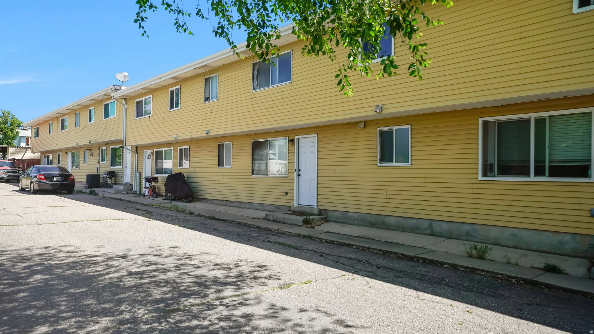 Multi-unit residential structure featuring yellow siding and white trim