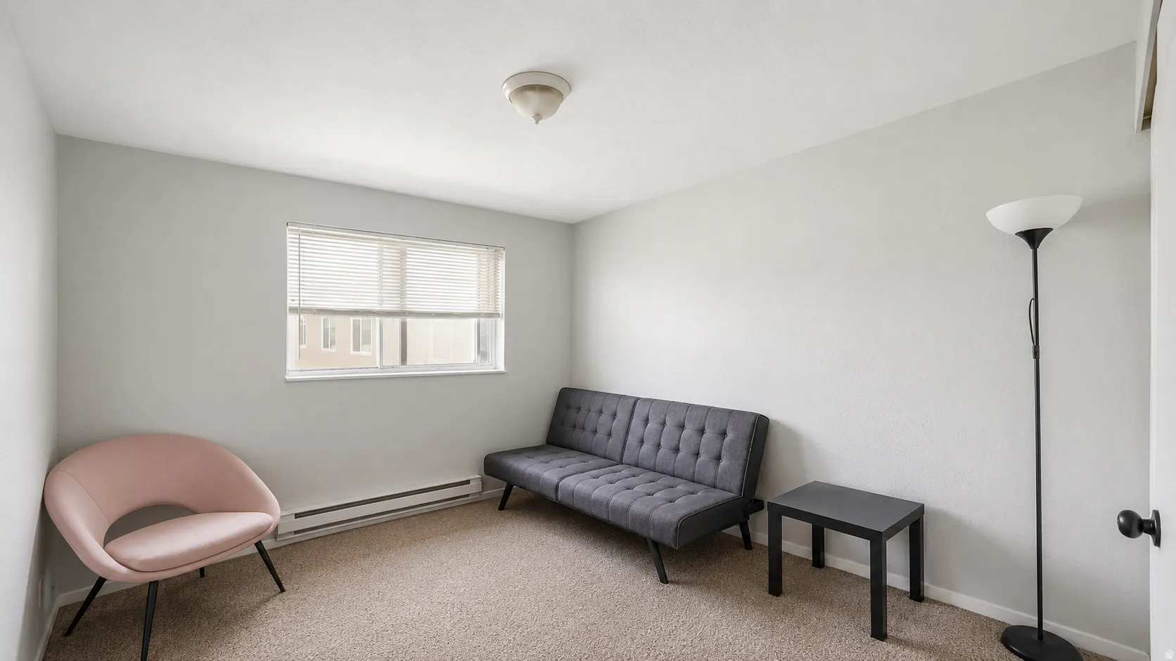 Neutral-toned walls complement the carpeted flooring in this bright room