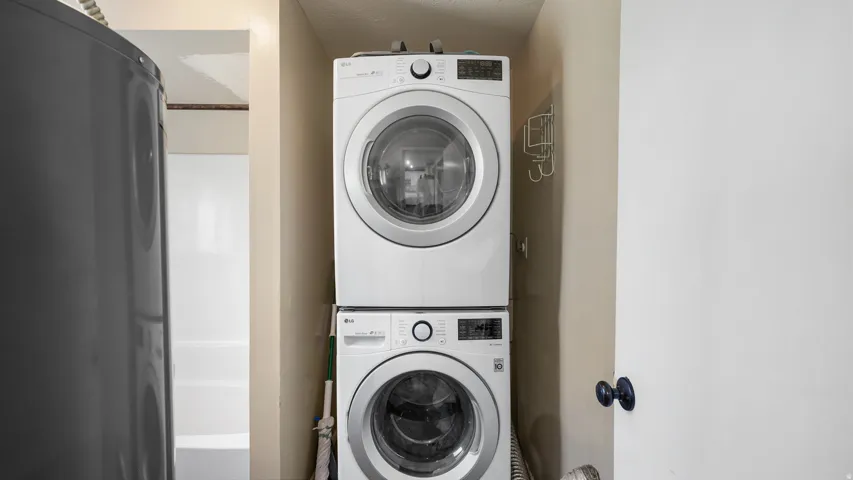 Dedicated laundry area featuring a stacked washer and dryer unit