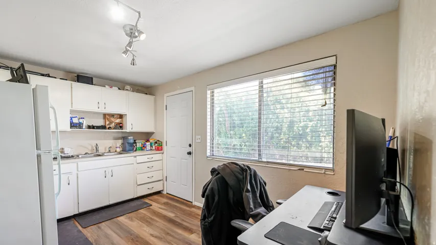 Kitchen area featuring white cabinetry, a single basin sink, and a white refrigerator