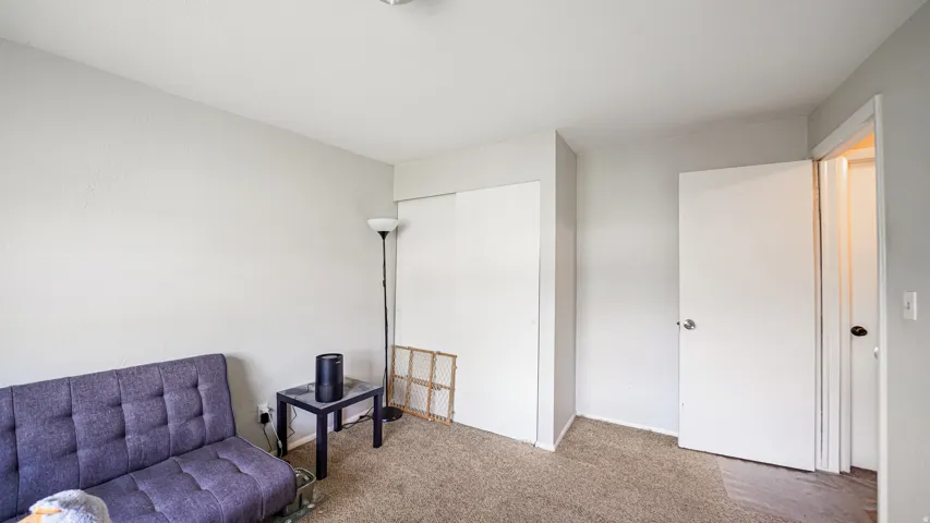 Neutral-toned room featuring light gray walls, textured carpeting, and white trim