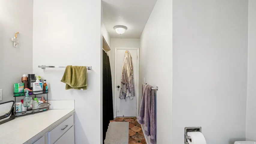 Bathroom featuring a light-colored countertop, white cabinetry with silver-tone pulls, and a built-in towel bar