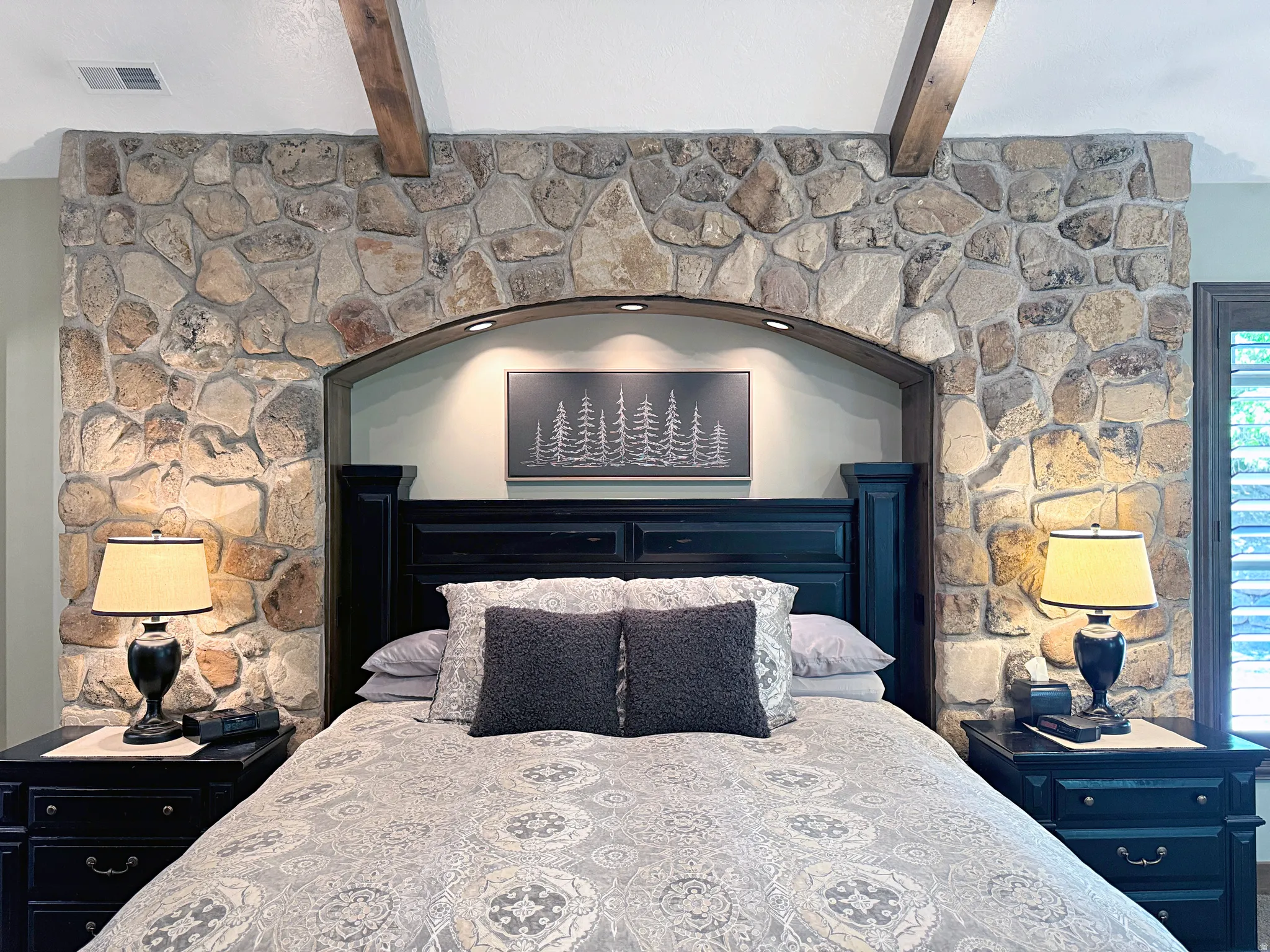Stone accent wall featuring an arched alcove with recessed lighting
