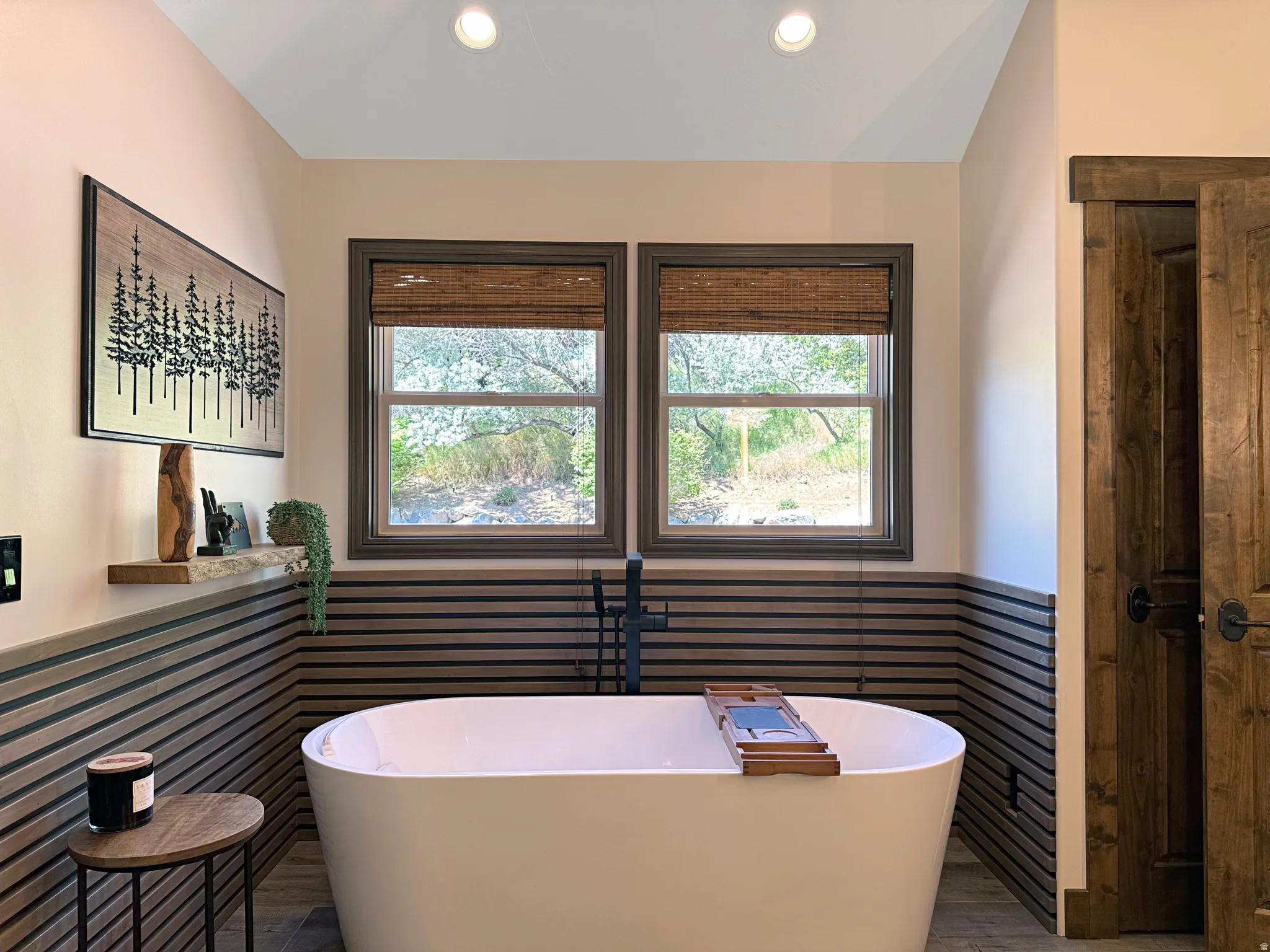 Freestanding soaking tub with dark-finish floor-mounted faucet