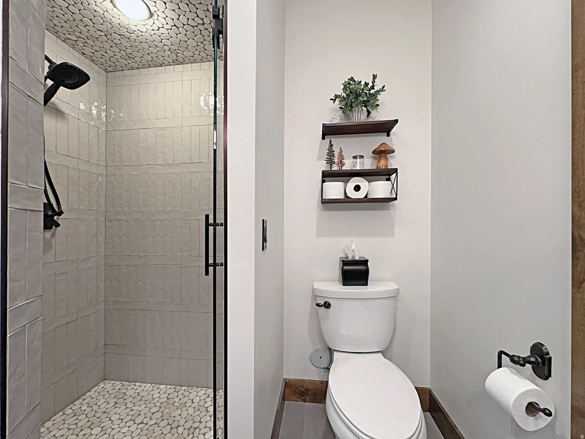 Walk-in shower with pebble tile floor and ceiling